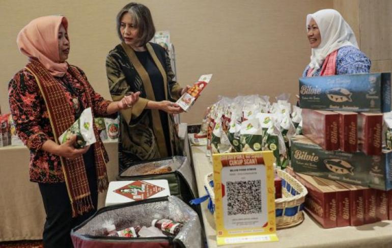 Co-Founder dan Chief Operating Officer DOKU, Nabilah Alsagoff (tengah) didampingi Ketua Umum Perkumpulan Wirausaha Pekerja Migran Indonesia, Sulistyaningsih (kiri) melihat produk UMKM makanan yang dipamerkan pada acara Strategic Partnership for Digital Future